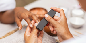 Maniküre: Kosmetikerin feilt die Nägel einer Person